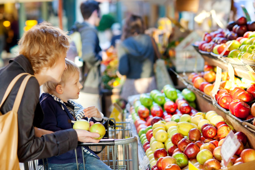 mother and her son buying fruits at a farmers market